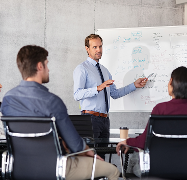 Man presenting on whiteboard ro colleagues